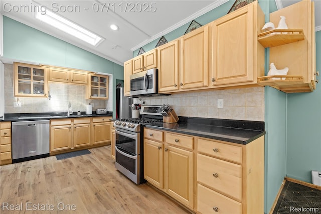 4217 Link Ave, Brighton, MI 48114 - kitchen featuring stainless steel appliances, light brown cabinetry, lofted ceiling, dark countertops, and light wood finished floors