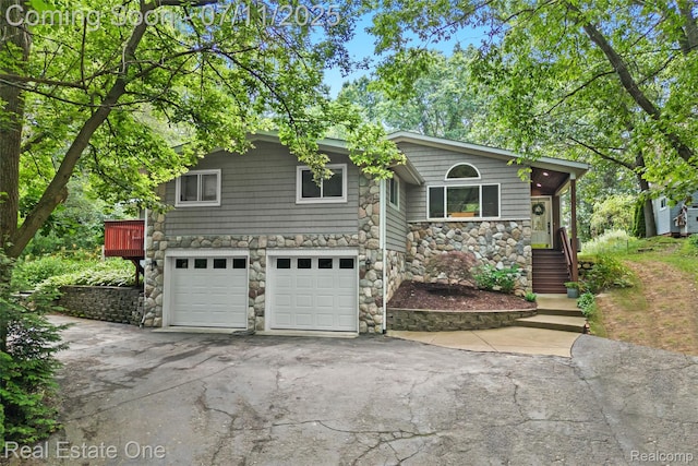 4217 Link Ave, Brighton, MI 48114 - view of front of house featuring stone siding, a garage, and driveway
