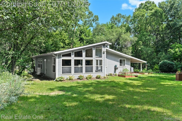 4217 Link Ave, Brighton, MI 48114 - back of house with a lawn and view of wooded area