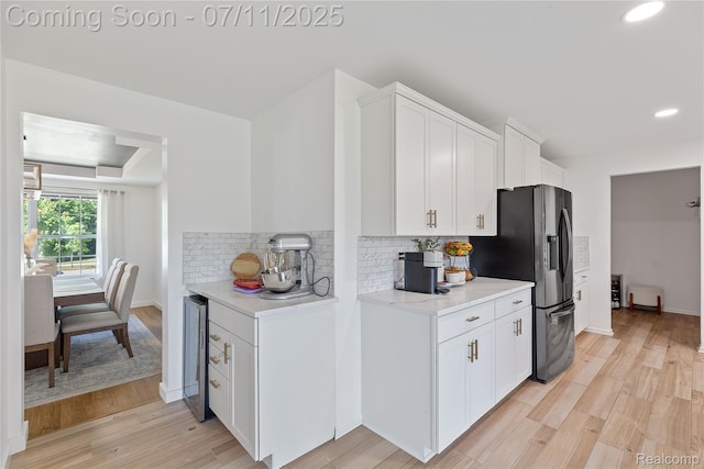 6649 Maplelawn Dr, Ypsilanti, MI 48197 - kitchen with stainless steel fridge with ice dispenser, light countertops, tasteful backsplash, light wood-type flooring, and white cabinets