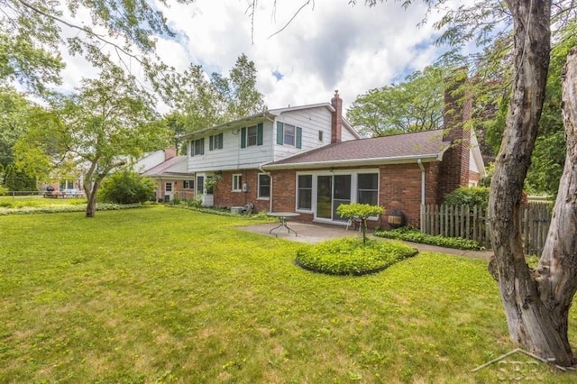 595 Stoneham Rd, Saginaw, MI 48638 - rear view of house with a chimney, brick siding, and a patio area
