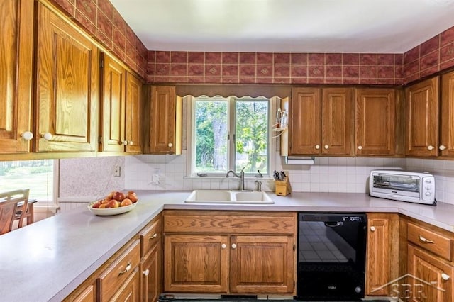 595 Stoneham Rd, Saginaw, MI 48638 - kitchen with black dishwasher, light countertops, brown cabinetry, and tasteful backsplash