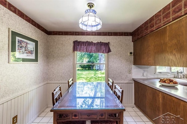 595 Stoneham Rd, Saginaw, MI 48638 - dining space with healthy amount of natural light, light tile patterned flooring, and a wainscoted wall