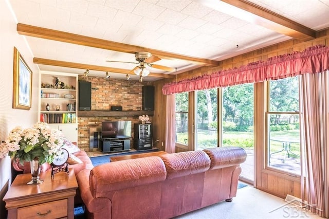 595 Stoneham Rd, Saginaw, MI 48638 - carpeted living area featuring beam ceiling, ceiling fan, wood walls, and built in features