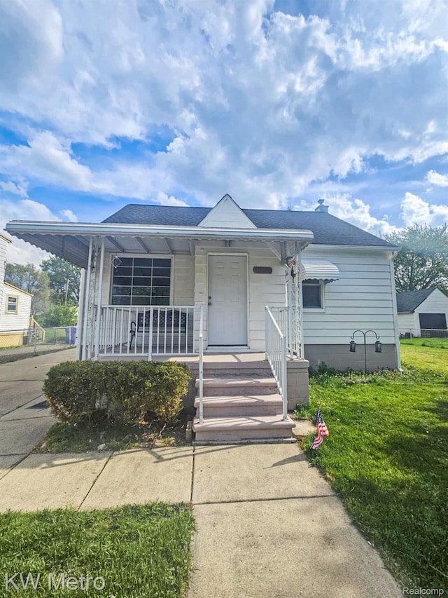 4010 Stolzenfeld Ave, Warren, MI 48091 - view of front of house with covered porch, roof with shingles, and a front yard