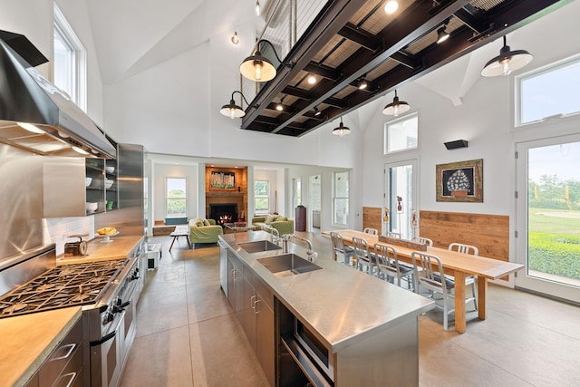 15337 Pardee Rd, Galien, MI 49113 - kitchen with stainless steel countertops, appliances with stainless steel finishes, a towering ceiling, wall chimney exhaust hood, and beamed ceiling