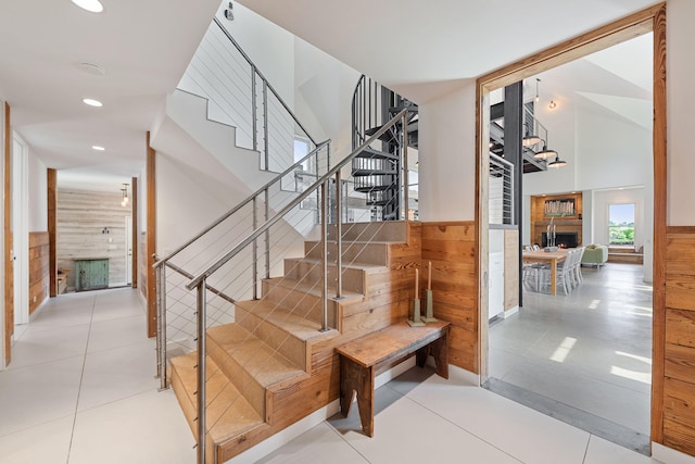 15337 Pardee Rd, Galien, MI 49113 - staircase with a lit fireplace, wood walls, recessed lighting, a wainscoted wall, and tile patterned flooring