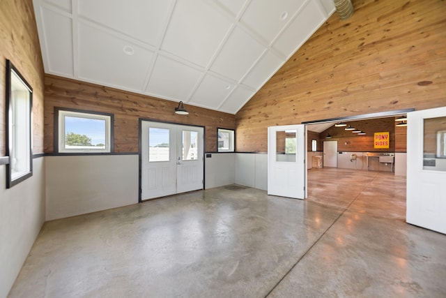 15337 Pardee Rd, Galien, MI 49113 - empty room with wooden walls, finished concrete floors, french doors, and high vaulted ceiling