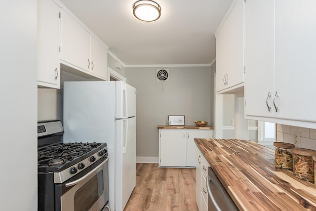 2931 Eastland Rd, Muskegon, MI 49441 - kitchen with butcher block countertops, stainless steel appliances, light wood-style flooring, white cabinets, and crown molding