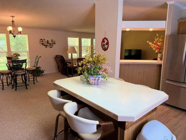 7878 Schooner Ln, Canadian Lakes, MI 49346 - dining area featuring a chandelier, a textured ceiling, and light carpet