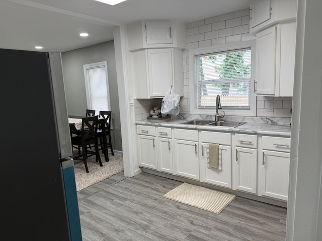 1008 Cooper Ave, Kalamazoo, MI 49048 - kitchen with freestanding refrigerator, white cabinets, recessed lighting, tasteful backsplash, and light wood-style flooring