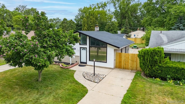 25288 Hopkins St, Dearborn Heights, MI 48125 - mid-century modern home featuring a chimney, a shingled roof, and view of scattered trees