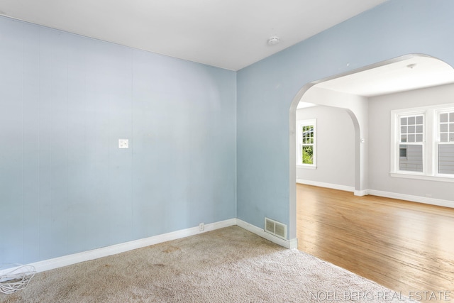 1307 Waverly Ave, Grand Haven, MI 49417 - unfurnished room with arched walkways, wood finished floors, and a smoke detector
