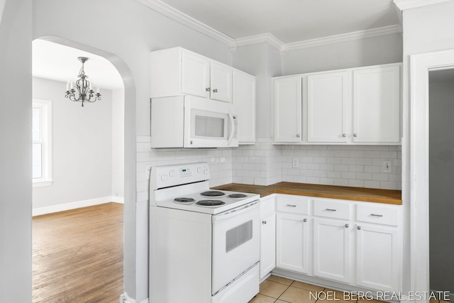 1307 Waverly Ave, Grand Haven, MI 49417 - kitchen with white appliances, arched walkways, white cabinets, a chandelier, and tasteful backsplash