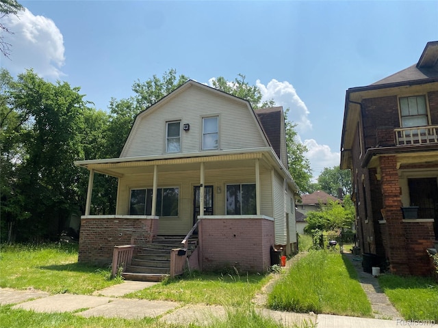 197 Richton St, Highland Park, MI 48203 - dutch colonial featuring a gambrel roof, covered porch, and stairway