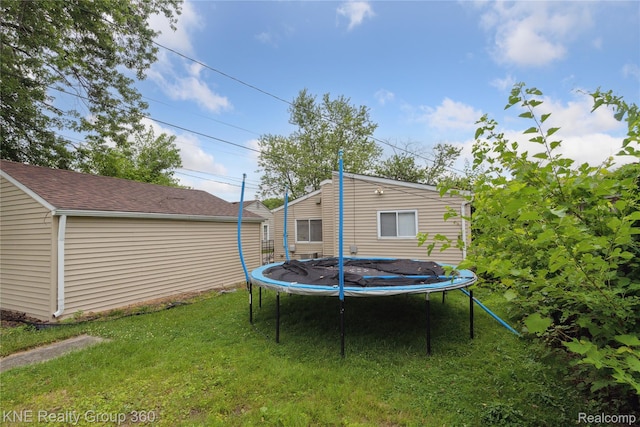 25143 Fern St, Roseville, MI 48066 - back of house featuring a trampoline, a lawn, an outdoor structure, and roof with shingles