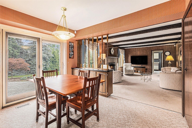 4213 Wentworth Dr, Troy, MI 48098 - carpeted dining space featuring a lit fireplace, beam ceiling, and wooden walls
