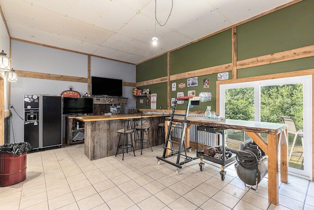 6671 E 136th St, Sand Lake, MI 49343 - kitchen with black fridge with ice dispenser, light tile patterned floors, and a peninsula