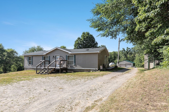 6671 E 136th St, Sand Lake, MI 49343 - manufactured / mobile home with an outbuilding, a garage, and a shingled roof