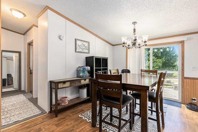 6671 E 136th St, Sand Lake, MI 49343 - dining area featuring ornamental molding, wood finished floors, a chandelier, a textured ceiling, and lofted ceiling