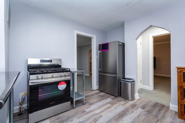 3602 Chatsworth St, Detroit, MI 48224 - kitchen with appliances with stainless steel finishes, arched walkways, and light wood-style floors