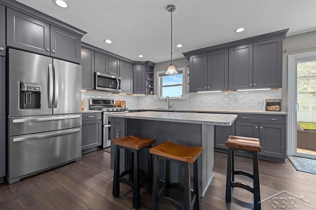 936 Appaloosa Pass, Auburn, MI 48611 - kitchen with appliances with stainless steel finishes, dark wood-style floors, open shelves, a center island, and decorative backsplash