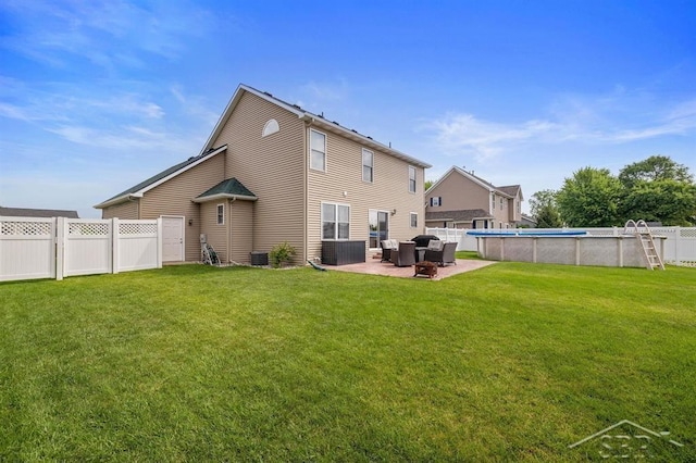 936 Appaloosa Pass, Auburn, MI 48611 - back of property with a fenced backyard, a patio area, an outdoor pool, and an outdoor hangout area