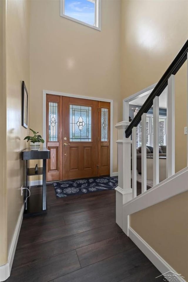 936 Appaloosa Pass, Auburn, MI 48611 - foyer with dark wood-style flooring, a high ceiling, healthy amount of natural light, and stairway