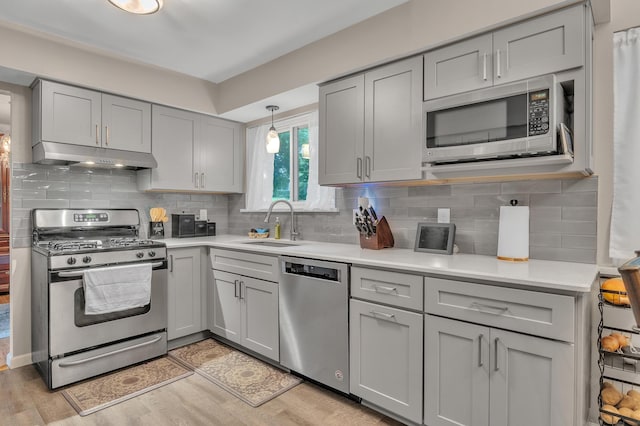 2840 Tuebingen Pkwy, Ann Arbor, MI 48105 - kitchen featuring stainless steel appliances, gray cabinets, under cabinet range hood, and light countertops