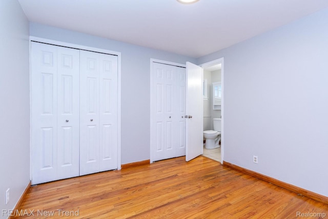 30604 Ann Arbor Trl, Westland, MI 48185 - unfurnished bedroom with multiple closets and light wood-style flooring
