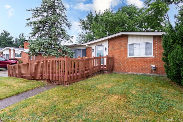 30604 Ann Arbor Trl, Westland, MI 48185 - back of house with a wooden deck, brick siding, and a yard
