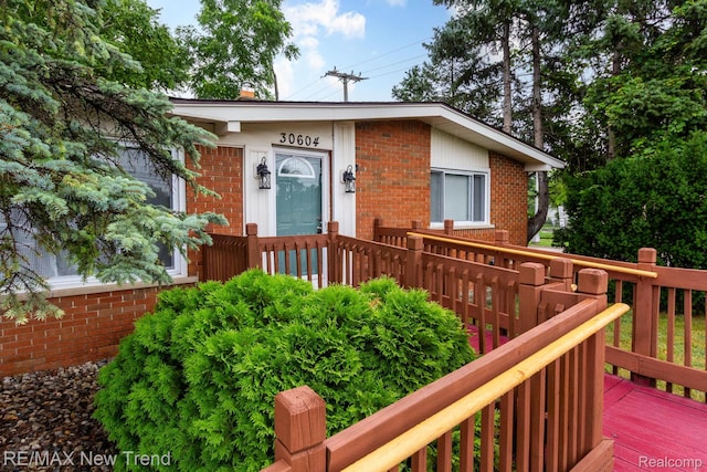 30604 Ann Arbor Trl, Westland, MI 48185 - view of front facade with brick siding, a wooden deck, and a chimney