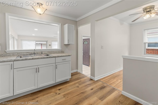 1681 Stieber St, Westland, MI 48186 - kitchen with light wood-type flooring, a ceiling fan, light countertops, crown molding, and white cabinets