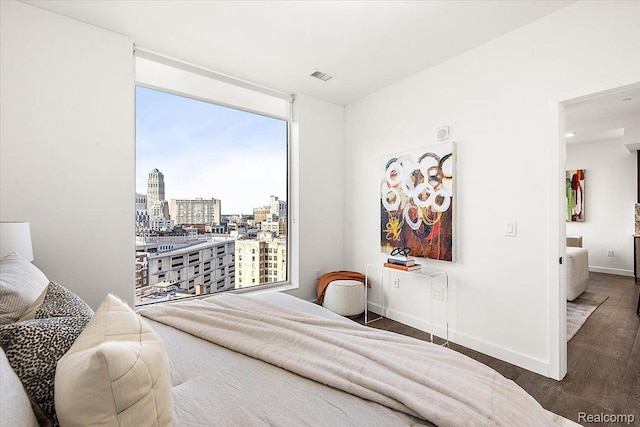 330 Gratiot Ave Unit 1504, Detroit, MI 48226 - bedroom featuring a city view, floor to ceiling windows, and wood finished floors