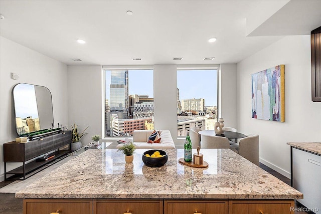 330 Gratiot Ave Unit 1504, Detroit, MI 48226 - kitchen featuring light stone countertops, wood finished floors, brown cabinetry, and recessed lighting