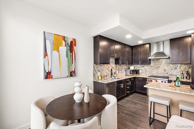 330 Gratiot Ave Unit 1504, Detroit, MI 48226 - kitchen with wall chimney exhaust hood, dark brown cabinets, decorative backsplash, dark wood-type flooring, and stainless steel appliances