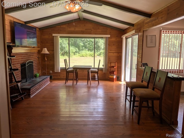 22048 Rougewood Dr, Southfield, MI 48033 - sitting room featuring a ceiling fan, wood walls, healthy amount of natural light, hardwood / wood-style floors, and a brick fireplace