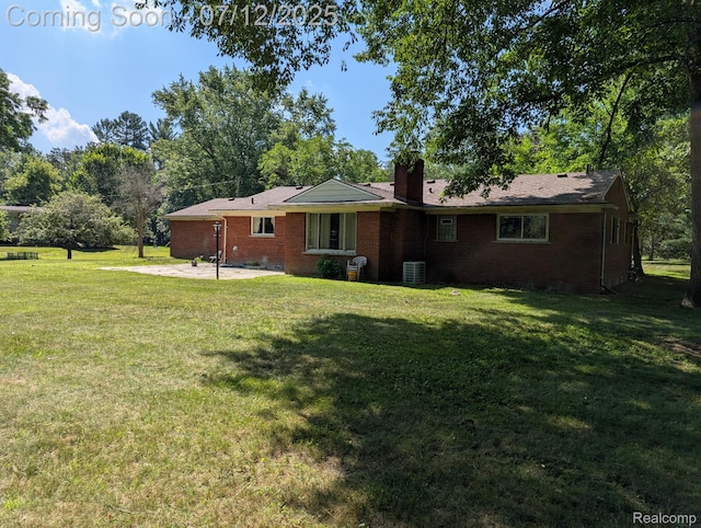22048 Rougewood Dr, Southfield, MI 48033 - view of front of house featuring a patio area, brick siding, a front yard, and a chimney