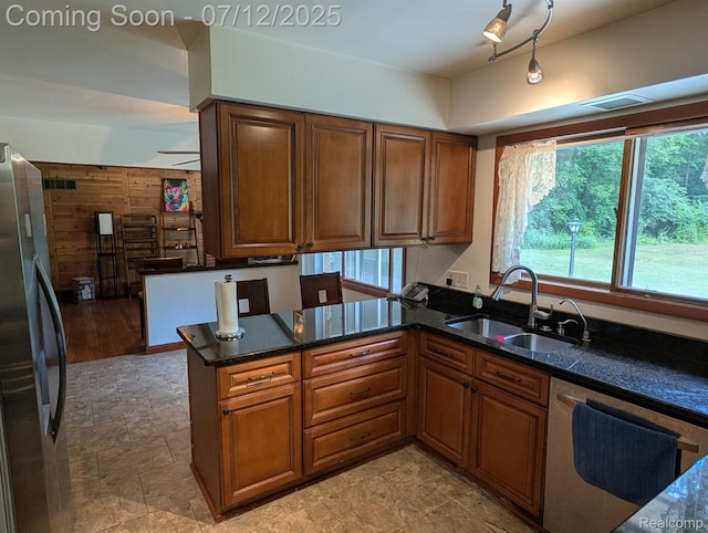 22048 Rougewood Dr, Southfield, MI 48033 - kitchen featuring dishwasher, freestanding refrigerator, a peninsula, plenty of natural light, and wooden walls