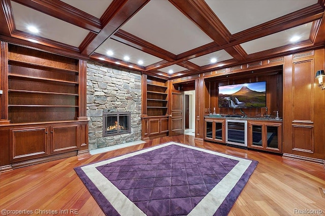 347 Pine Ridge Dr, Bloomfield Hills, MI 48304 - unfurnished living room with wine cooler, wood finished floors, a stone fireplace, built in shelves, and beam ceiling