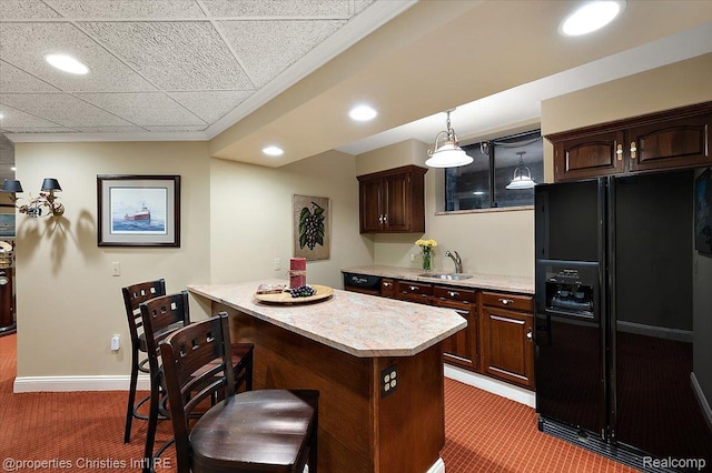 347 Pine Ridge Dr, Bloomfield Hills, MI 48304 - kitchen featuring black fridge, light countertops, light carpet, a breakfast bar, and recessed lighting