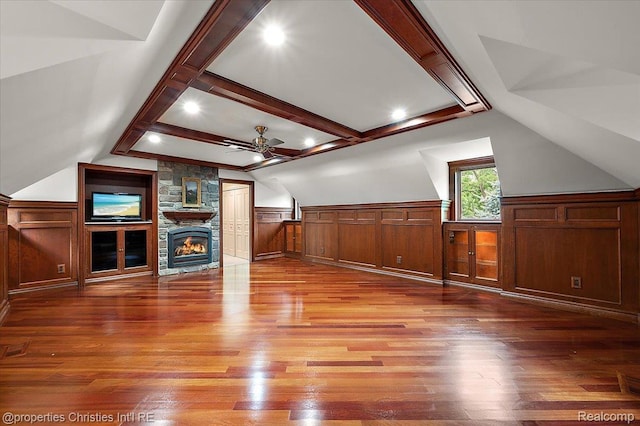 347 Pine Ridge Dr, Bloomfield Hills, MI 48304 - unfurnished living room with ceiling fan, a wainscoted wall, light wood finished floors, a stone fireplace, and a decorative wall