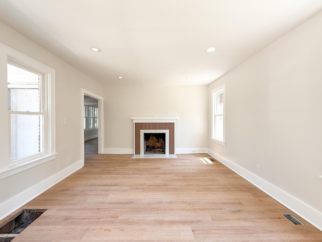 15786 Rutherford St, Detroit, MI 48227 - unfurnished living room featuring healthy amount of natural light, a fireplace with flush hearth, recessed lighting, and light wood-style flooring