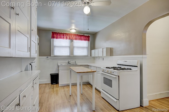 515 W Golden Gate, Detroit, MI 48203 - kitchen featuring white range with gas stovetop, a ceiling fan, white cabinetry, arched walkways, and light countertops