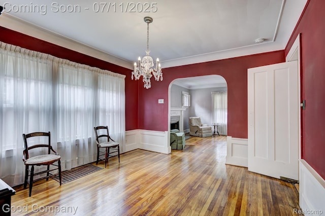 515 W Golden Gate, Detroit, MI 48203 - living area with arched walkways, plenty of natural light, a wainscoted wall, hardwood / wood-style floors, and a fireplace