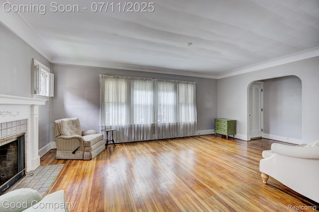 515 W Golden Gate, Detroit, MI 48203 - living room with arched walkways, wood finished floors, a tiled fireplace, and ornamental molding