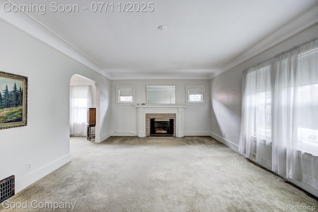 515 W Golden Gate, Detroit, MI 48203 - unfurnished living room featuring arched walkways, a brick fireplace, and carpet floors