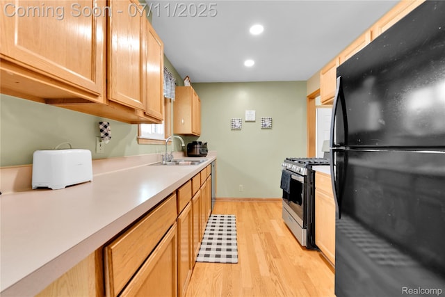 34019 Arrowhead St, Canton, MI 48185 - kitchen with freestanding refrigerator, stainless steel range with gas cooktop, light wood finished floors, light countertops, and light brown cabinetry