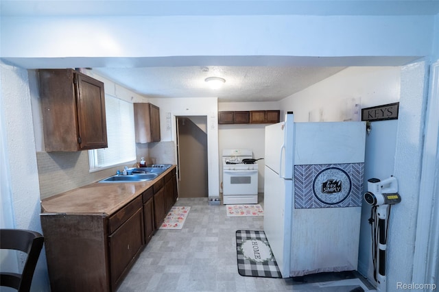 14599 Coyle St, Detroit, MI 48227 - kitchen with white appliances, dark brown cabinets, light countertops, and light floors