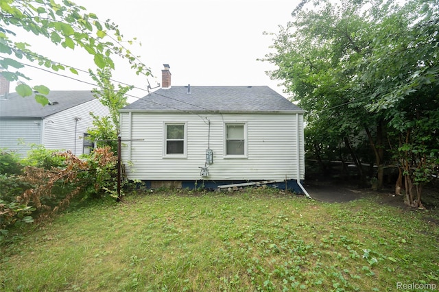 14599 Coyle St, Detroit, MI 48227 - rear view of house featuring a chimney and a yard